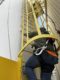 Matt Bonanni, Salesman of Harriman Material Handling, pictured climbing an outdoor ladder utilizing updated fall protection equipment required by OSHA.